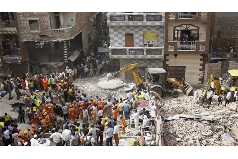 Mitarbeiter der National Disaster Response Force und Freiwillige führen Rettungsarbeiten durch, nachdem ein mehrstöckiges Gebäude in den frühen Morgenstunden im Stadtteil Mustafabad Dayalpur in Neu-Delhi, Indien, eingestürzt ist.