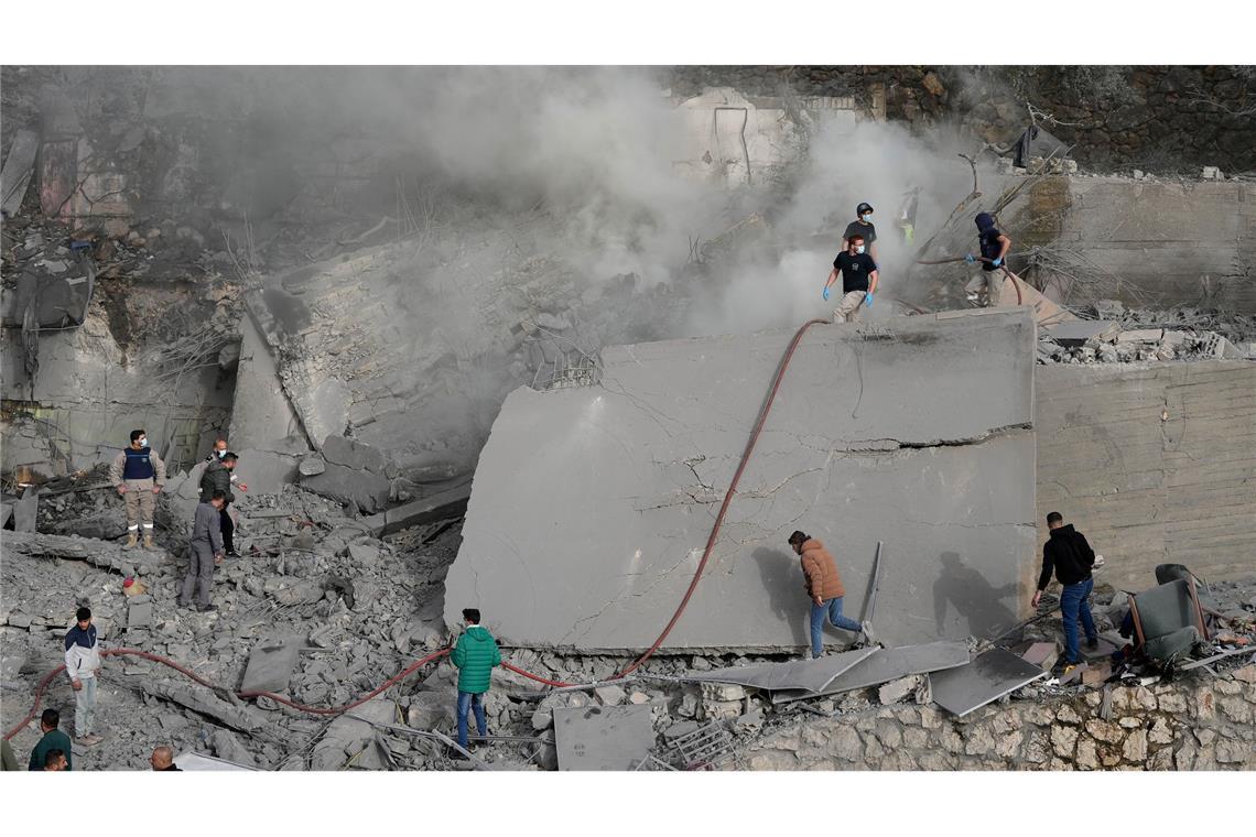 Mitarbeiter des Zivilschutzes und Zivilisten überprüfen ein zerstörtes Gebäude, das von einem israelischen Luftangriff in dem Ort im Südlibanon getroffen wurde.