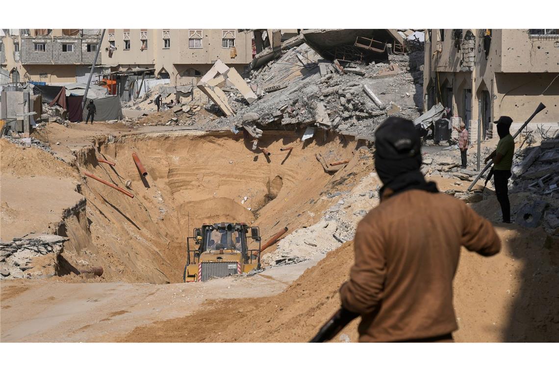 Mitglieder der islamistischen Hamas suchen nach Leichen israelischer Geiseln.