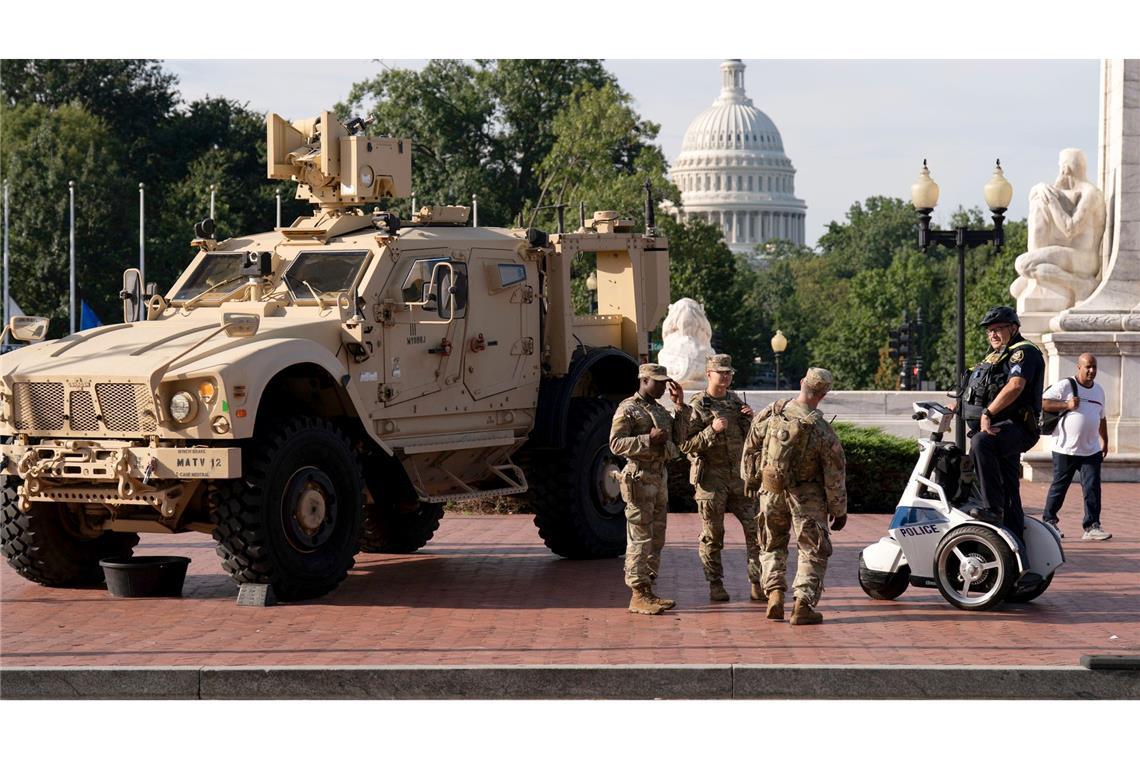 Bilder des Tages Mitglieder der Nationalgarde, die auf Anordnung von Präsident Trump in der US-Hauptstadt Washington sind, stehen neben einem gepanzerten Fahrzeug.