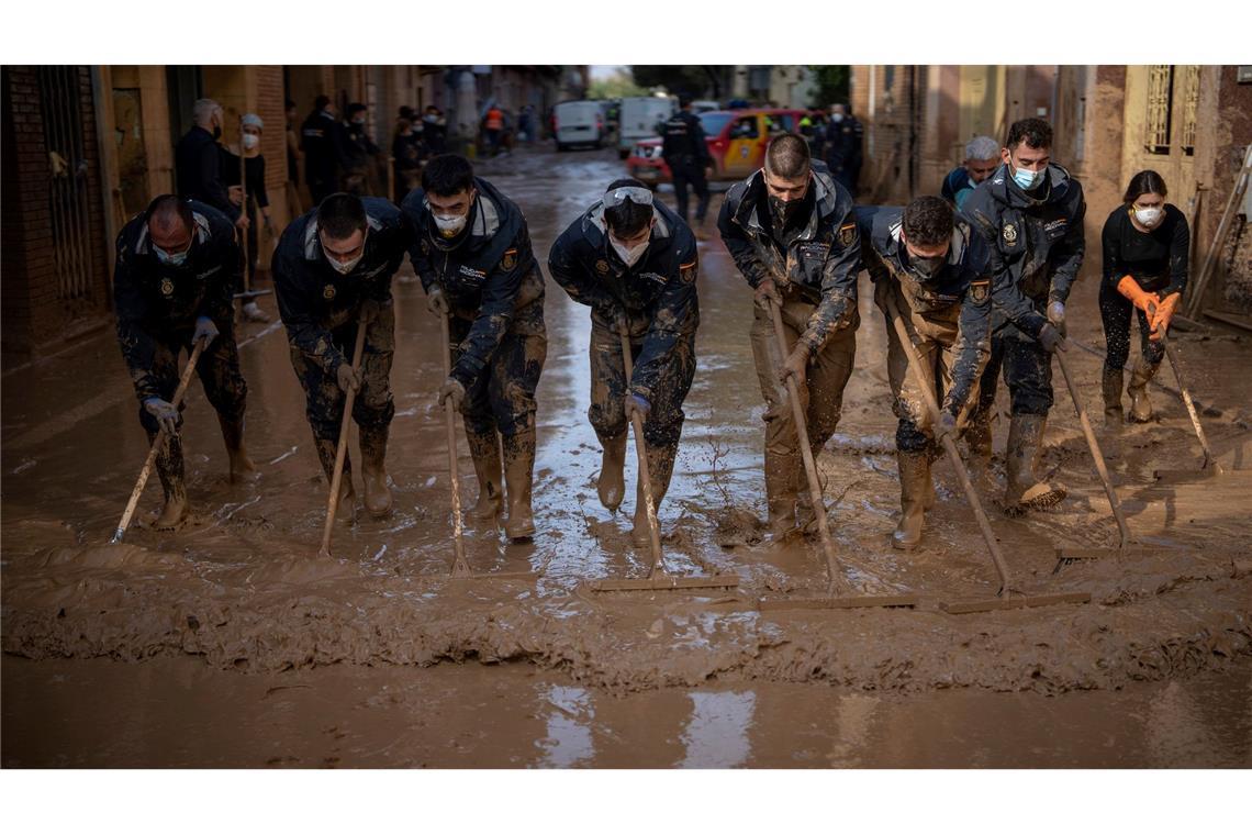 Bilder des Tages Mitglieder der spanischen Nationalpolizei beseitigen Schlamm in einem von den schweren Überschwemmungen betroffenen Gebiet in der Provinz Valencia.