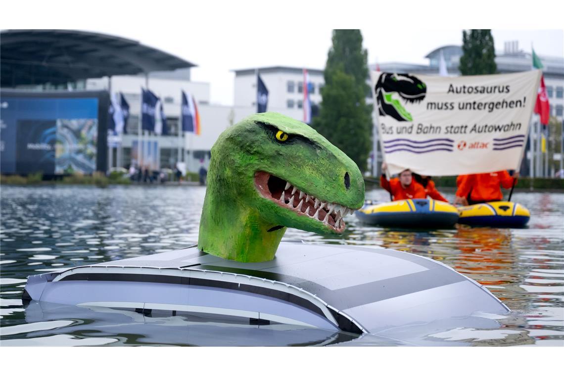 Mitglieder von Attac demonstrieren vor der Eröffnung der Internationalen Automobil-Ausstellung (IAA Mobility) in München mit einem „Autosaurus“ für eine Mobilitätswende.