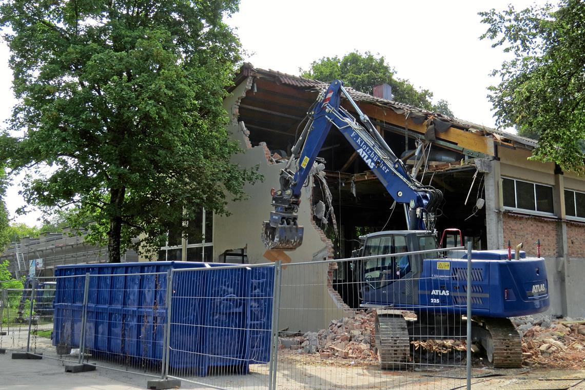 Turnhallenabriss geht voran Mittlerweile hat der Bagger schon ein großes Loch in die Flanke der Halle gerissen. Foto: Christine Schick
