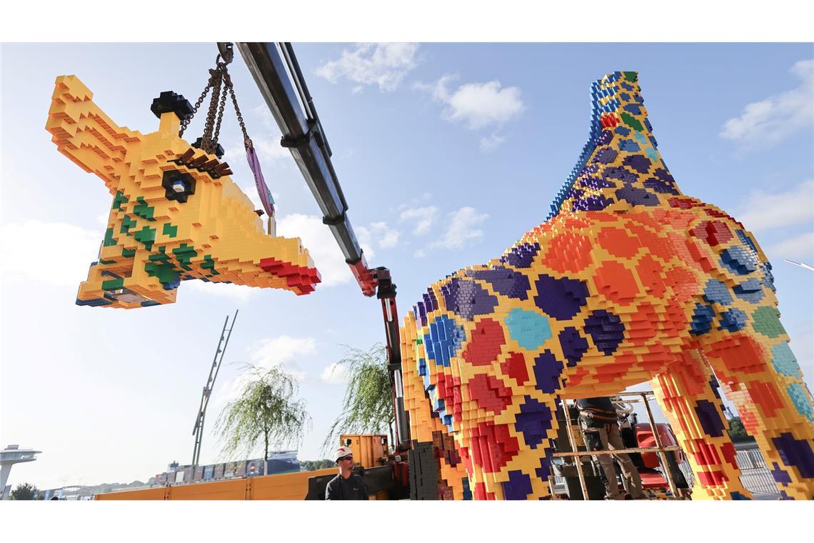 Modellbauer arbeiten an der finalen Arbeiten an einer lebensgroßen Lego-Giraffe auf dem Chicagokai vor dem Westfield Hamburg-Überseequartier in der Hafencity.