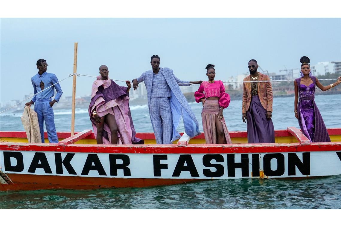 Models präsentieren Kreationen auf einem traditionellen Fischerboot.