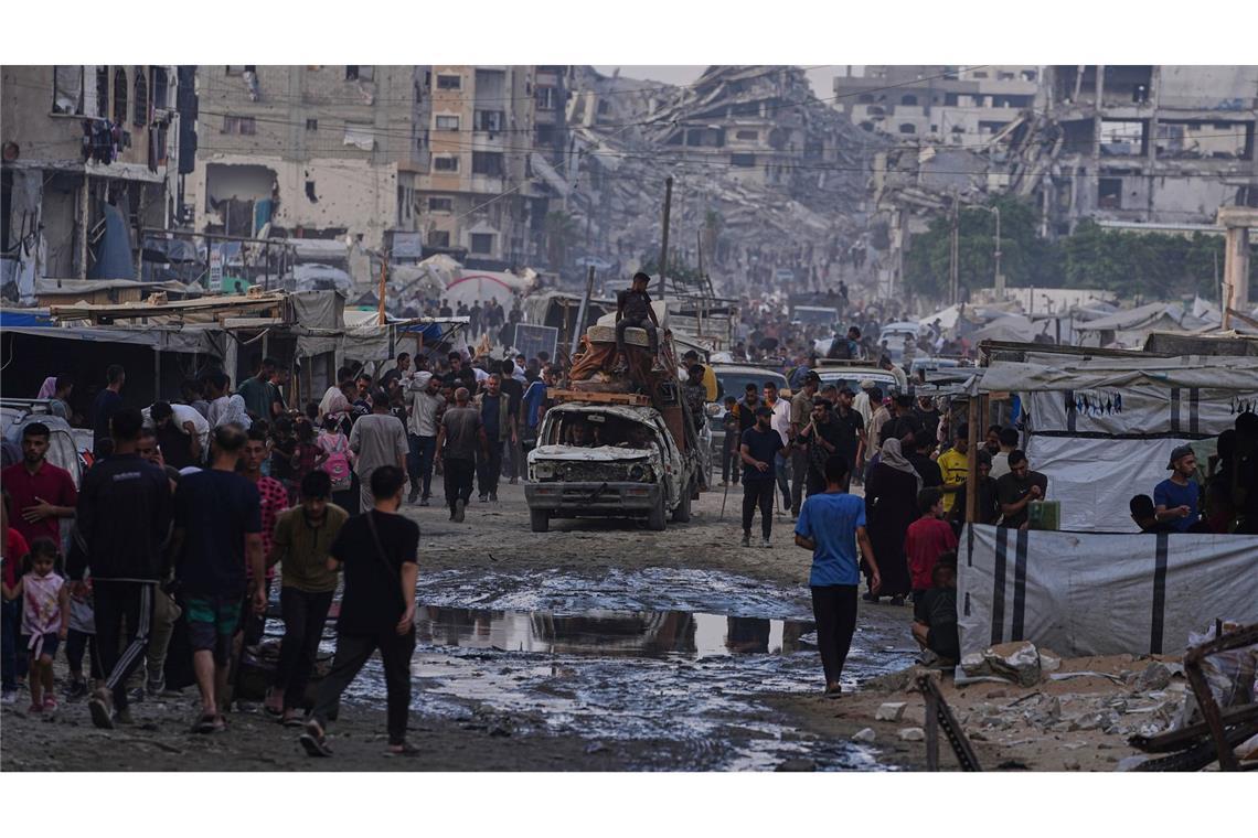 Bilder des Tages Möbel und eine Matratze werden mit einem beschädigen Auto zwischen Fußgängern durch einen Markt in Gaza-Stadt transportiert.