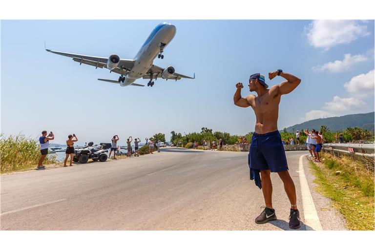 Muckis gegen Düsenkraft: Dieser Poser am Flughafen der griechischen Insel Skiathos wirkt  zwar etwas lächerlich, zumindest ist er aber durch das startende Flugzeug nicht gefährdet.