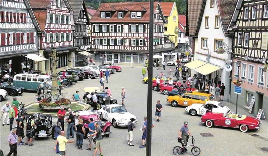 MURRHARDT (cs).Die letzte Etappe der 12. Internationalen Weinstraßen-Rallye führte auch durch Murrhardt. Die rund 70 Teilnehmer der „Vino Miglia“ machten in der Walterichstadt Station, wo sie Bürgermeister Armin Mößner empfing und sie ihre prachtvollen Schlitten, Liebhabermodelle und Oldtimer auf dem Marktplatz präsentierten. So hatten die Murrhardter Gelegenheit, mit Veranstaltern und Fahrern ins Gespräch zu kommen und die Technik der unterschiedlich alten Veteranen (1930er- bis 1970er-Jahre) zu begutachten. Organisiert wird die Tour vom Automobil-Club Maikammer gemeinsam mit dem ADAC. Die aktuelle „Vino Miglia“ führte vom 15. bis 22. Juni in sieben Etappen über 1800 Kilometer von Neustadt an der Weinstraße durch vier Länder und über bis zu 2500 Meter hohe Alpenpässe nach Meran in Südtirol und wieder zurück. Begleitet wurde die Tour von der Pfälzer Weinkönigin Meike Klohr, die für Murrhardter Kostproben der guten Tropfen bereithielt. Das Begleiterteam gab Interessierten kompakte Infos zur 12. Tourenauflage in Form einer Broschüre mit. Zur Rallye gehören übrigens auch Zeit- und Fahrprüfungen auf jeder Etappe, bei der ein Tages- und zum Schluss ein Gesamtsieger gekürt wird. Weitere Infos: www.vino-miglia.de. Foto: C. Schick