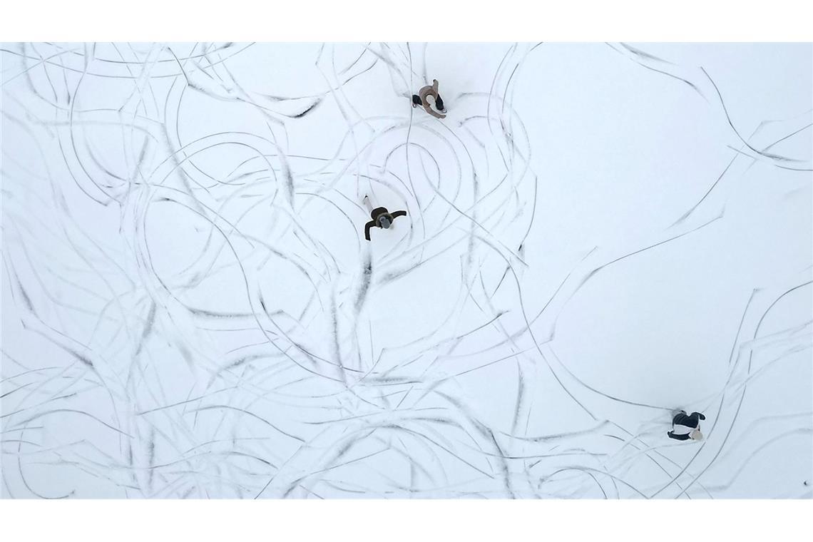 Muster im Schnee: Eine Luftaufnahme zeigt Schlittschuhläufer auf einem zugefrorenen See in Österreich.