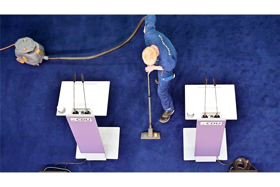 Bilder des Tages Nach der Bundestagswahl - Ein Mitarbeiter reinigt mit einem Staubsauger das Podium vor einer Pressekonferenz nach der Sitzung des CDU-Vorstands im Konrad-Adenauer-Haus.
