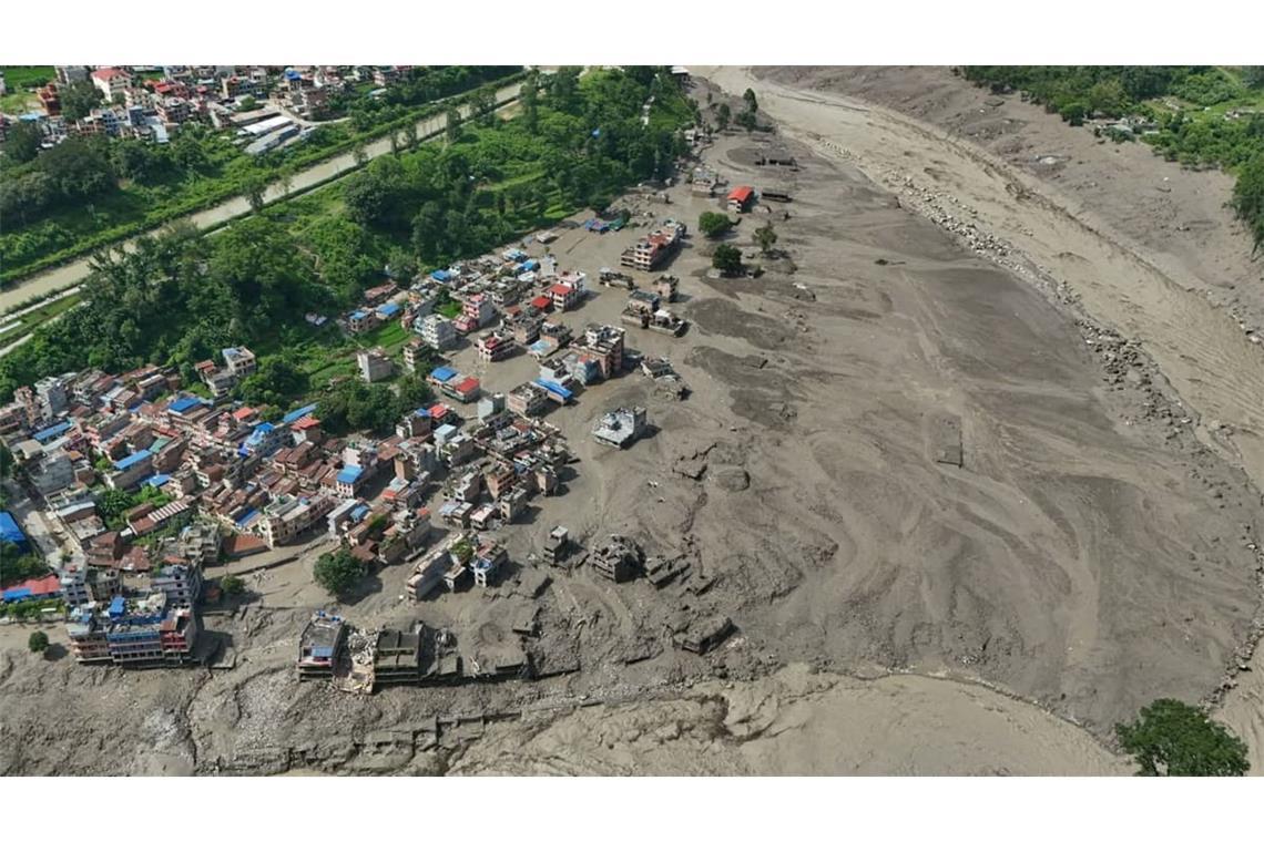 Nach Sturzfluten im nepalesischen Distrikt Nuwakot stehen beschädigte Häuser gefährlich nahe an den angeschwollenen, mit Treibgut verstopften Ufern des Trishuli-Flusses. Eine massive Sturzflut in Nepal hat nach Behördenangeben einigen Menschen das Leben gekostet.