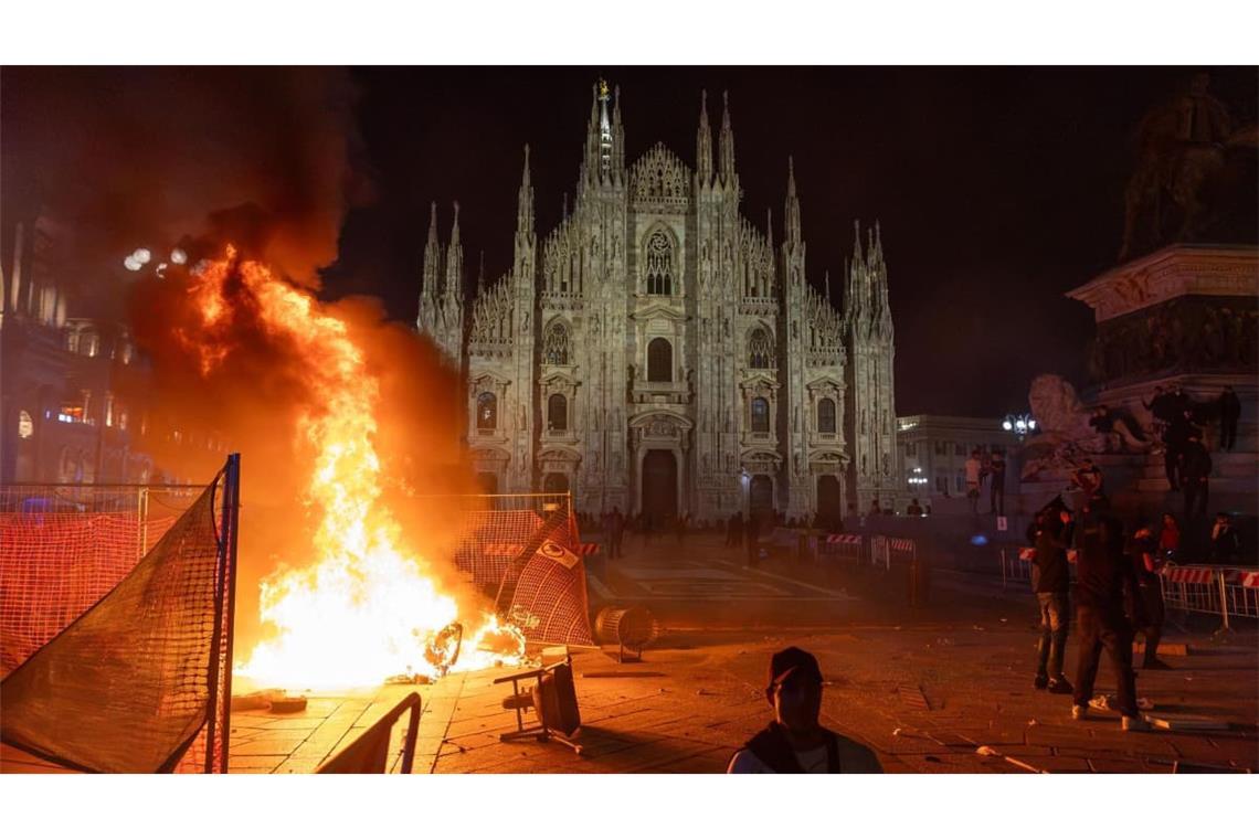 Nach Zusammenstößen zwischen der Polizei und Demonstranten der Bewegung „Italia in Piazza“ vor dem Mailänder Dom brennt ein Feuer.