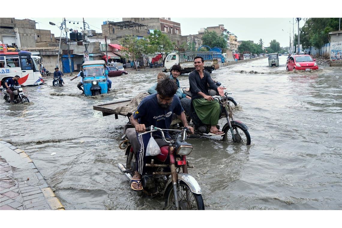 Bilder des Tages Nasse Füße bekommen diese Motorradfahrer nach schweren Regenfällen im pakistanischen Karachi.