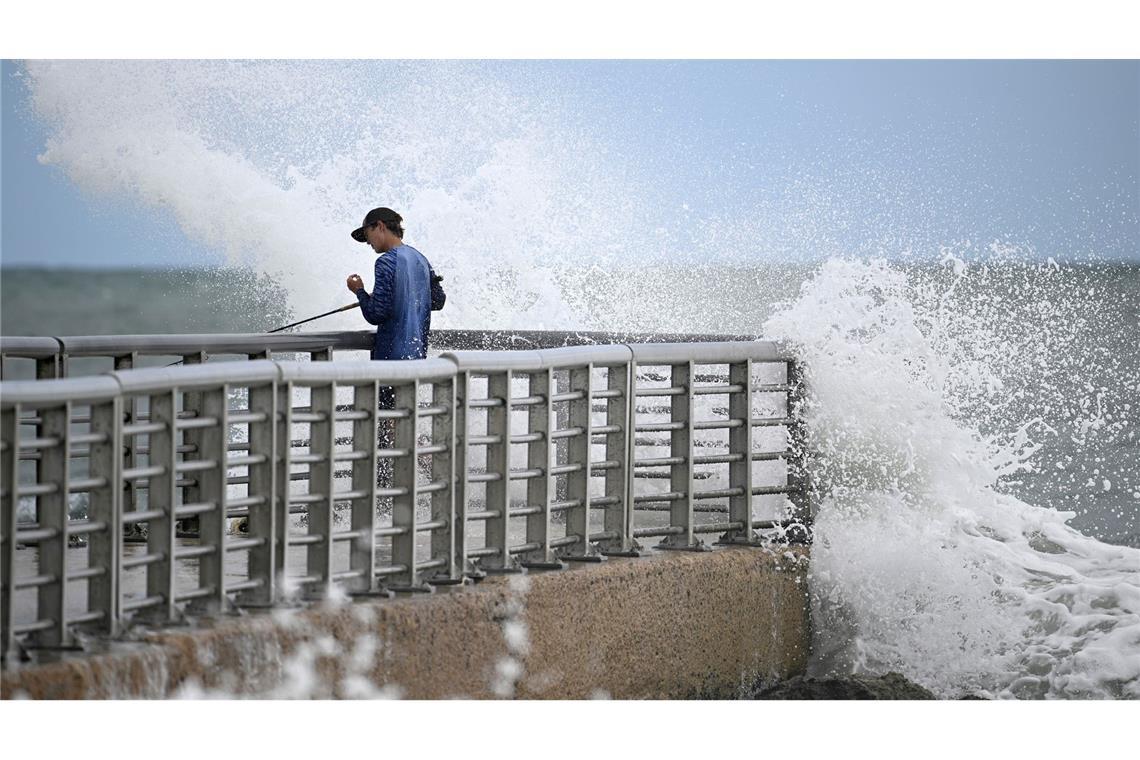 Bilder des Tages Nathan Goff wird beim Angeln auf dem Steg im Sebastian Inlet State Park von einer Welle durchnässt, als der Tropensturm Imelda in Melbourne Beach, Florida, an der Küste vorbeizieht.