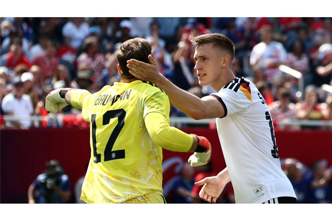 Nico Schlotterbeck (r) gratuliert Oliver Baumann nach einer Parade.