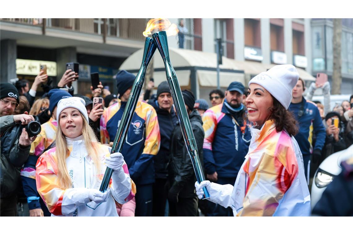 Olympische Winterspiele: Athletinnen beim Fackellauf mit der Flamme in Cortina D'ampezzo.