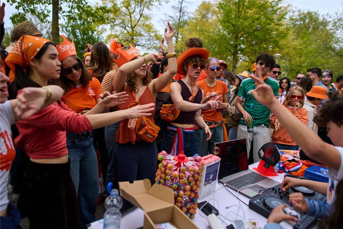 Orange gekleidete Feiernde tanzen zur Musik eines jungen DJs, während sie am Königstag den 59. Geburtstag des niederländischen Königs Willem-Alexander feiern.