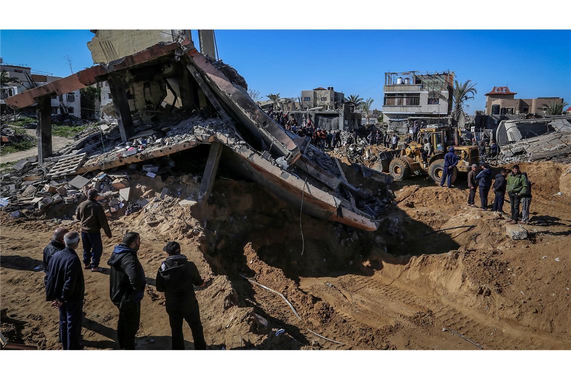 Hamas-Behörde: Mehr als 50.000 Gaza-Tote seit Kriegsbeginn Palästinenser beobachten, wie Mitarbeiter des Zivilschutzes Leichen aus den Trümmern eines durch einen israelischen Luftangriff zerstörten Hauses bergen.
