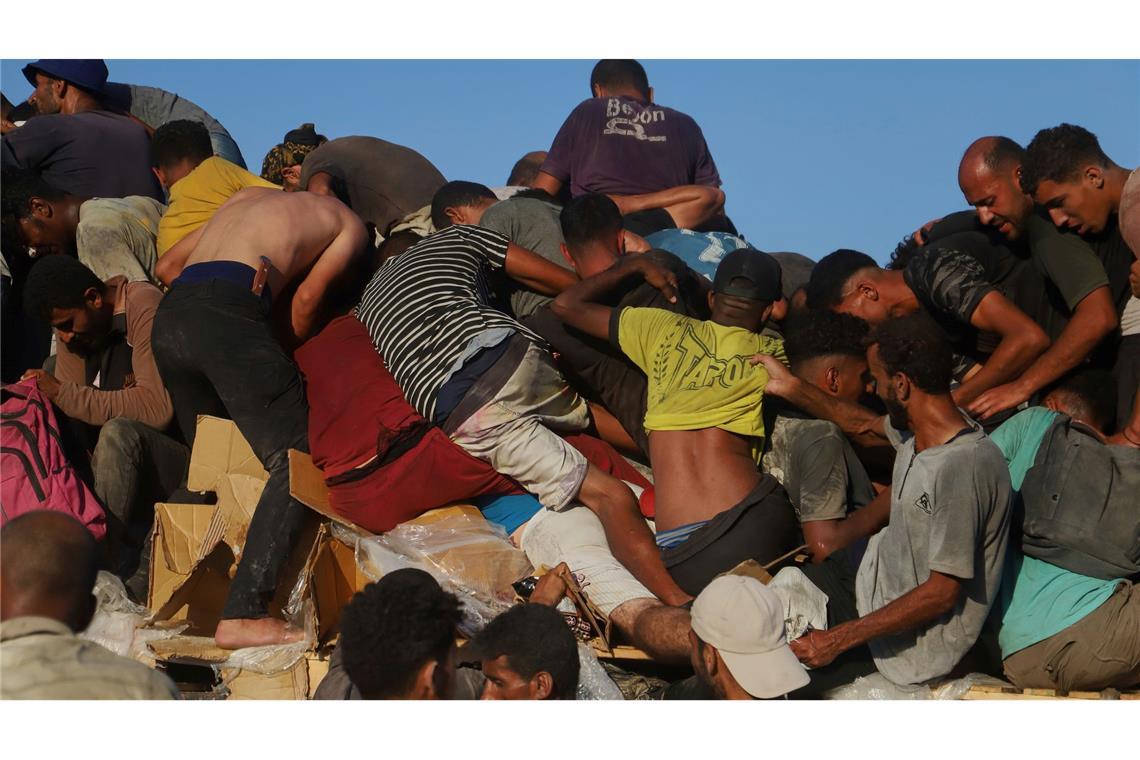 Palästinenser fahren auf einem mit Lebensmitteln und humanitärer Hilfe beladenen Lastwagen durch den Morag-Korridor in der Nähe von Rafah.