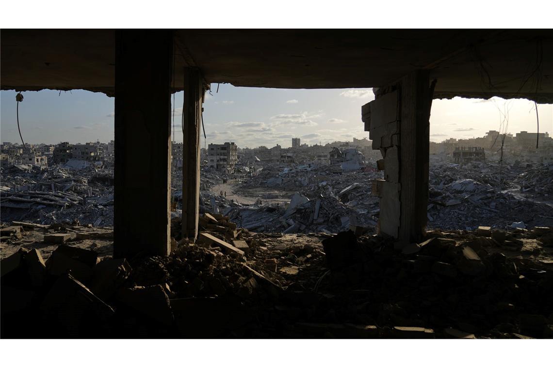 Palästinenser gehen zwischen den Trümmern der Stadt Gaza.