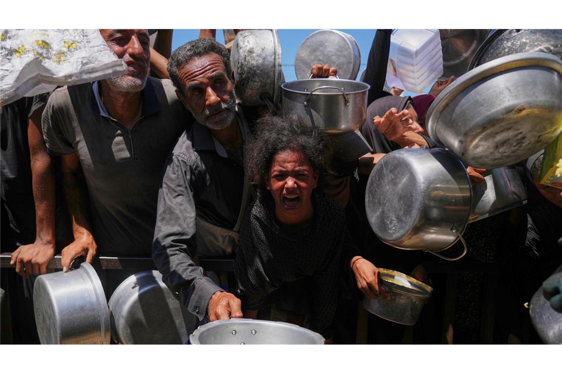 Bilder des Tages Palästinenser kämpfen um gespendete Lebensmittel in einer Gemeinschaftsküche im südlichen Gazastreifen.