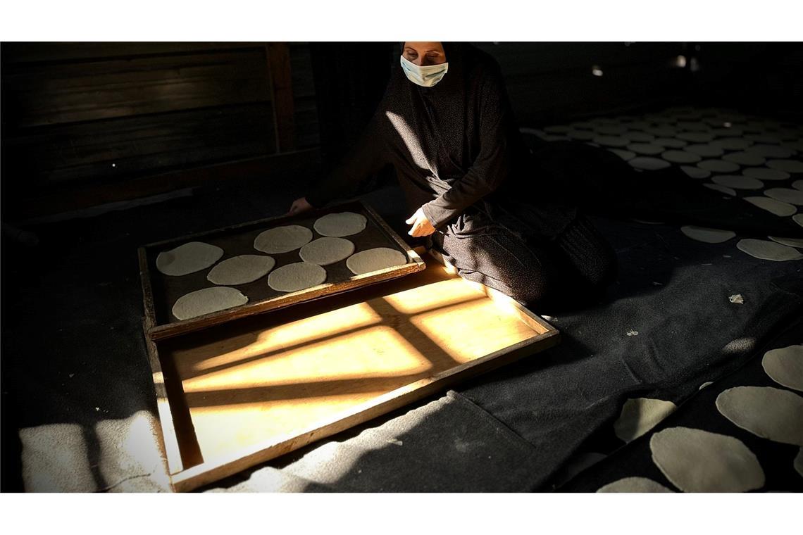 Bilder des Tages Palästinensische Frauen backen freiwillig Brot, um im Rahmen einer Wohltätigkeitsaktion Hunderte von Vertriebenen im Lager Al-Mawasi zu versorgen.