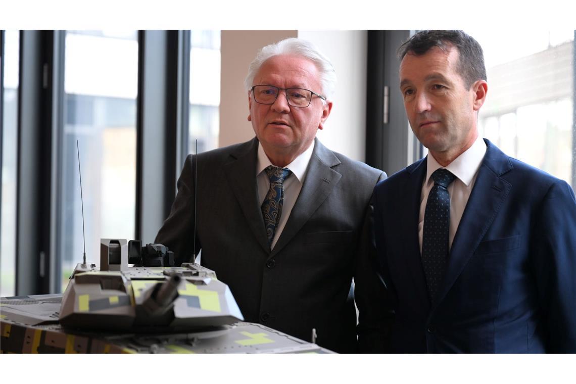 Papperger und Escribano bei einem Modell des Rheinmetall-Kampfpanzers Panther.