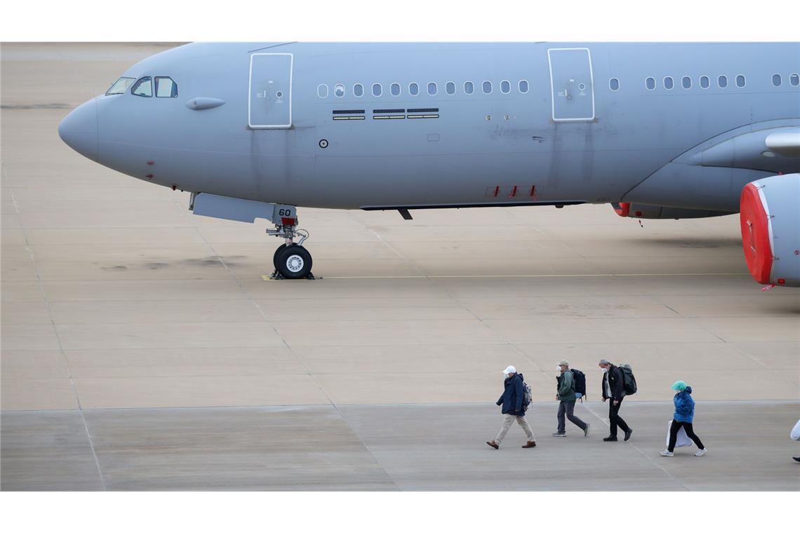 Passagiere des von einem Hantavirus-Ausbruch betroffenen Kreuzfahrtschiffs steigen am Flughafen Eindhoven aus einem Flugzeug aus.