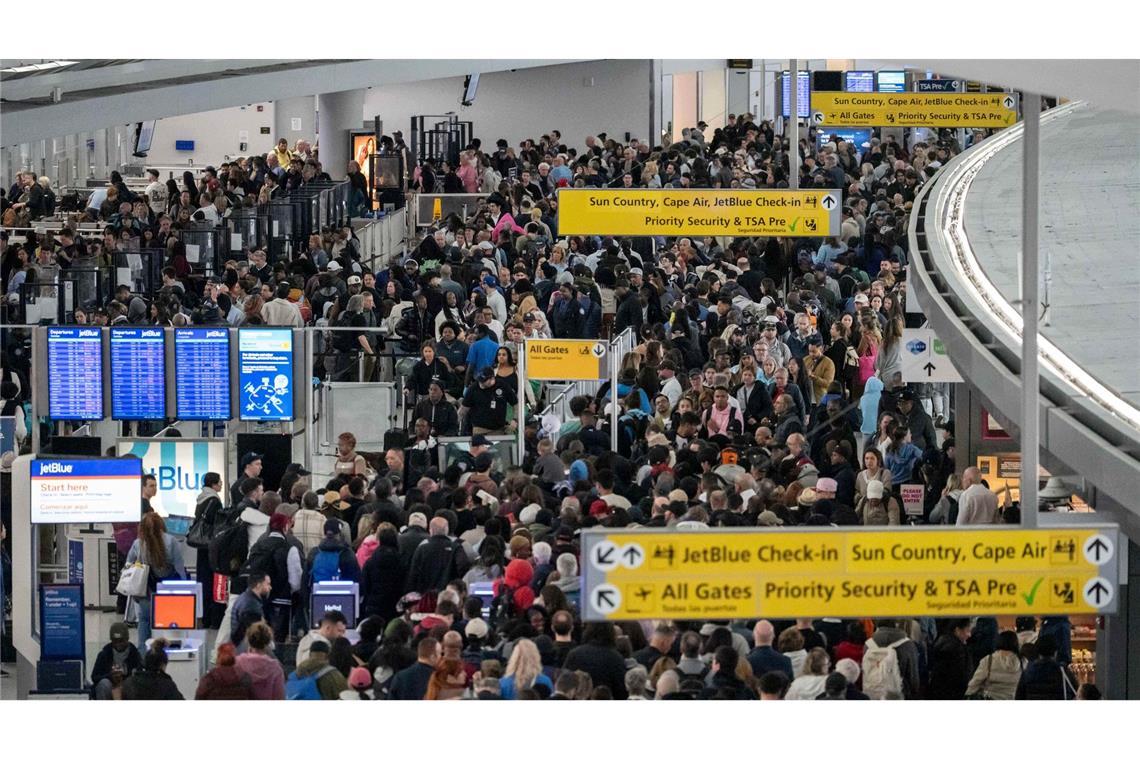 Passagiere warten in einer TSA-Schlange.