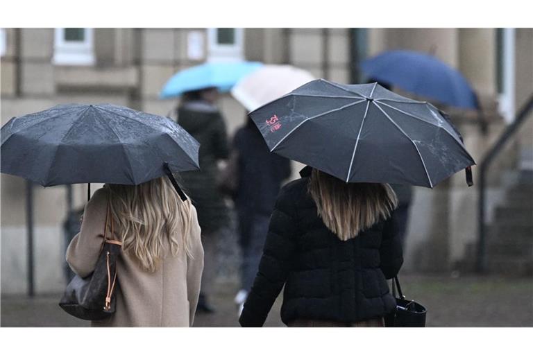 Passanten mit Regenschirmen laufen über den Schlossplatz. Der Deutsche Wetterdienst warnt vor Dauerregen: Bis Donnerstag könnten örtlich bis zu 100 Liter pro Quadratmeter fallen. (zu dpa: «Am Sonntag wird es im Südwesten regnerisch und kühl»)