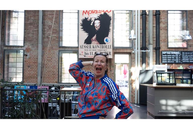 Patrizia Moresco steht im Theaterhaus-Foyer vor dem Plakat, das für ihre neue Show „Außer Kontrolle“ wirbt.
