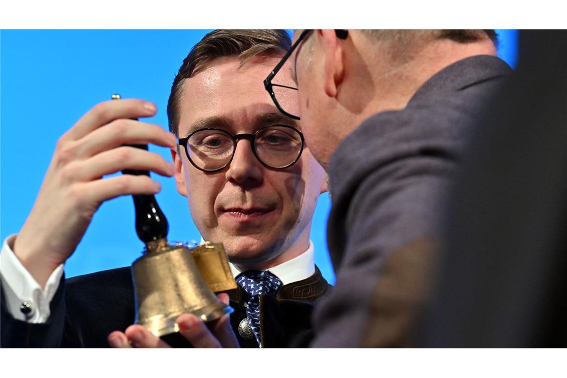 Bilder des Tages Philipp Amthor hält eine Tischglocke samt Anhänger mit der Aufschrift "Politischer Aschermittwoch Glockenstadt Apolda 5. März 2025" in den Händen beim Politischen Aschermittwoch der CDU Thüringen.