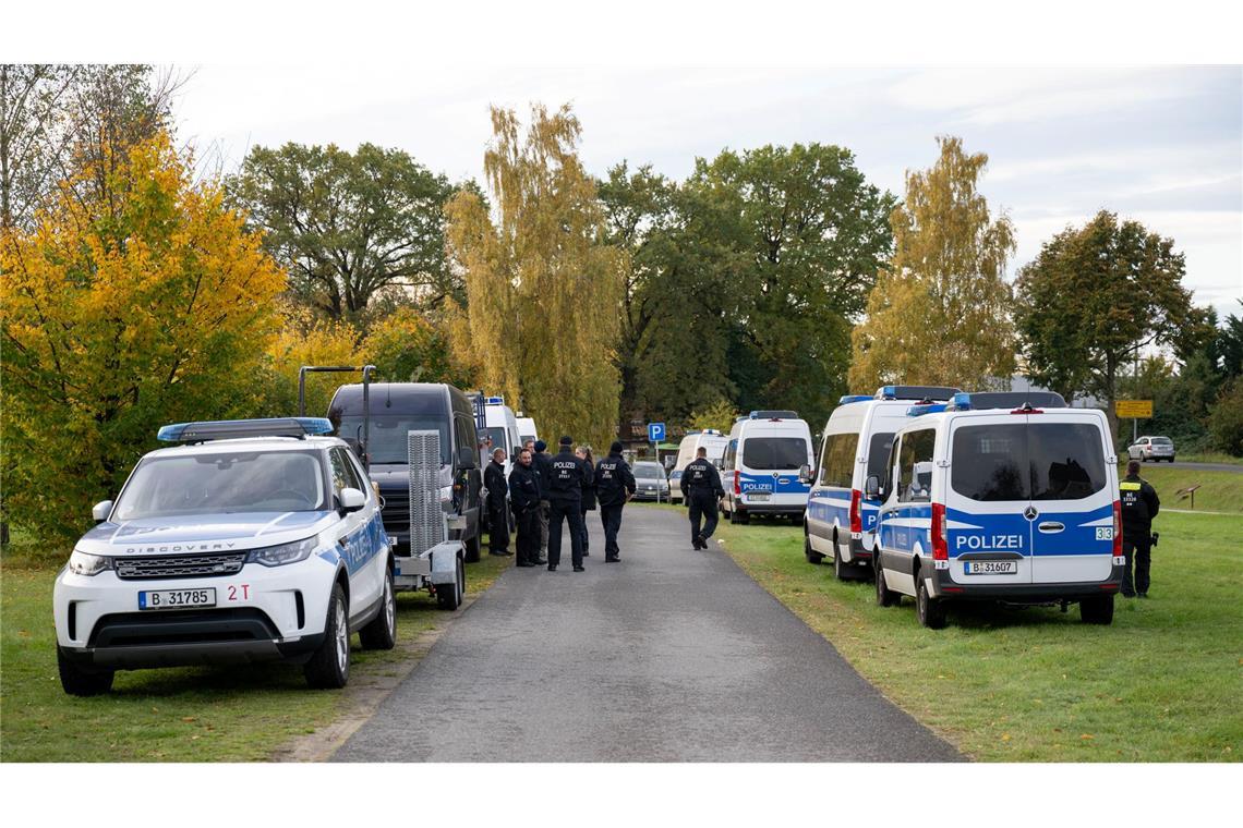 Polizeiautos stehen auf einer Wiese in Tauche.