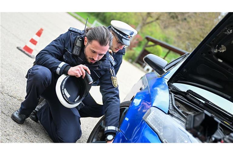 Polizeibeamte kontrollieren ein Auto, das von einer Verkehrskontrolle am „Car-Freitag“ herausgezogen wurde.