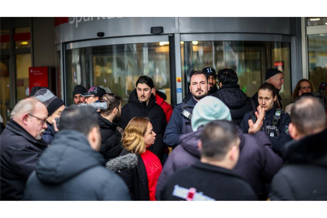 Polizeibeamte sprechen mit möglicherweise betroffenen Kunden der Sparkassenfiliale in Buer.