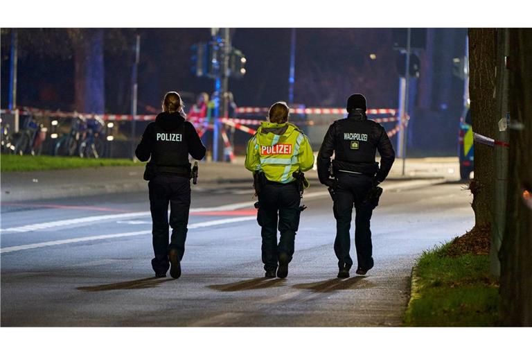 Polizeibeamte streifen durch den abgesperrten Bereich des Geschehens.