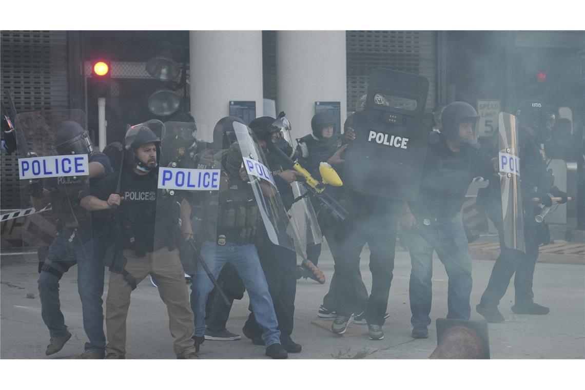 Razzien maskierter und bewaffneter Beamter gegen Migranten lösen Proteste aus Polizeibeamte versammeln sich, während Tränengas die Luft füllt, während eines Protests, nachdem die Bundeseinwanderungsbehörden in Los Angeles eine Operation durchgeführt haben.