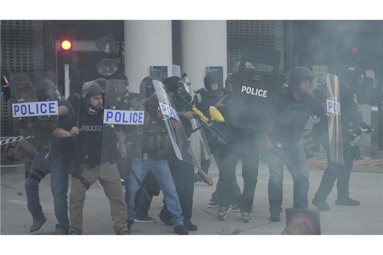 Polizeibeamte versammeln sich, während Tränengas die Luft füllt, während eines Protests, nachdem die Bundeseinwanderungsbehörden in Los Angeles eine Operation durchgeführt haben.