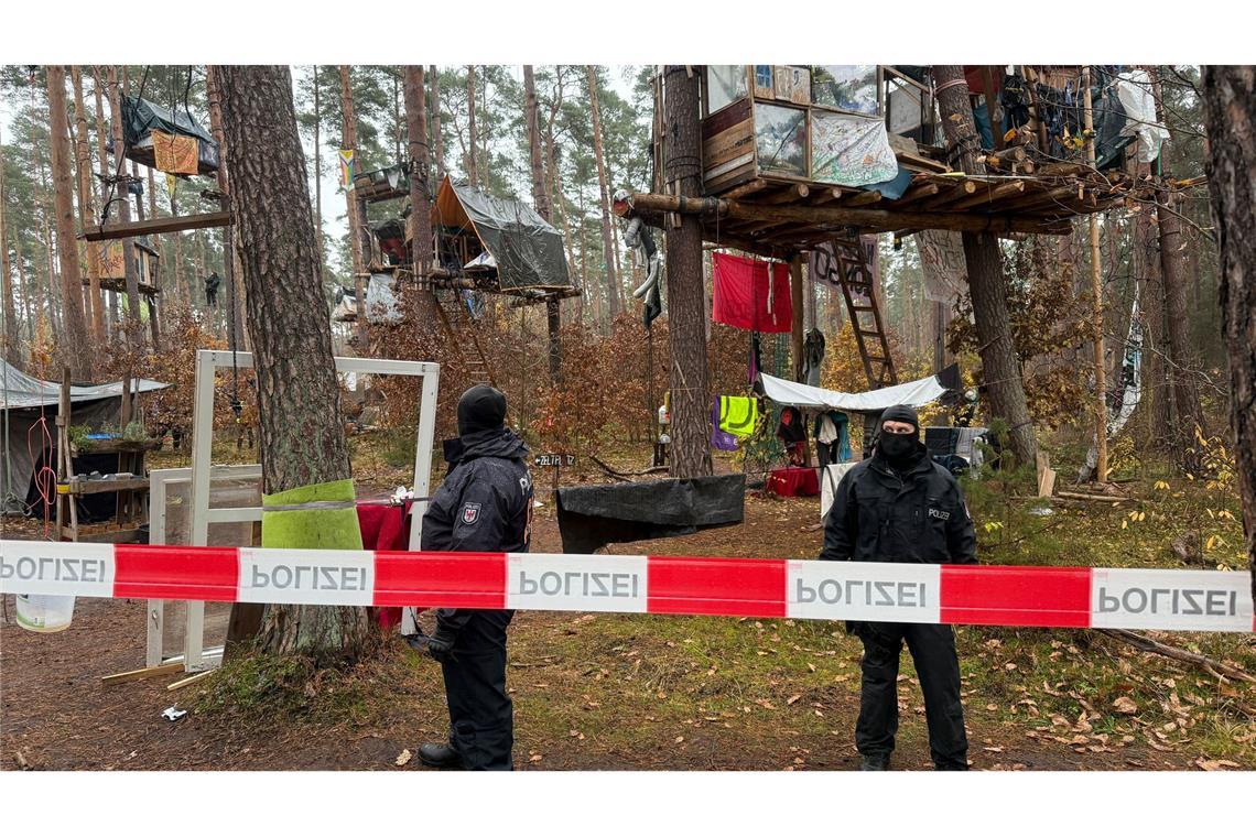 Polizei löst Tesla-Protestcamp komplett auf Polizeikräfte sichern das Waldgebiet hinter einer Absperrung. Umweltaktivisten, die gegen Tesla protestieren, müssen ihr Camp räumen.