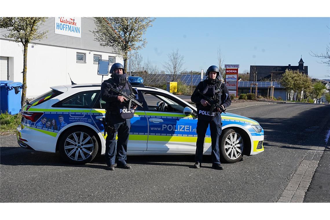 Drei Tote im Westerwald - Was wir wissen und was nicht Polizisten am Ortseingang von Weitefeld.