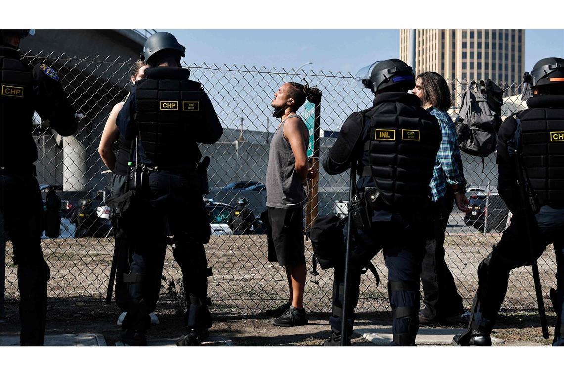 Festnahmen wegen Verstößen gegen die Ausgangssperre Polizisten in LA nehmen Demonstranten fest.