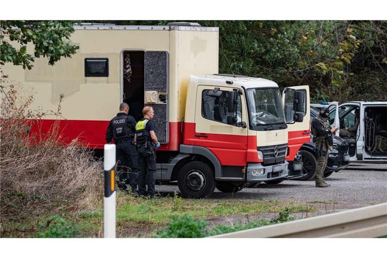 Polizisten in Spezialausrüstung sind an einem Lkw im Einsatz. Die Polizei hat laut NRW-Innenminister Reul in Niederzier das Fahrzeug des Verdächtigen für mehrere Sabotageaktionen gegen die deutsche Stromversorgung gestürmt.