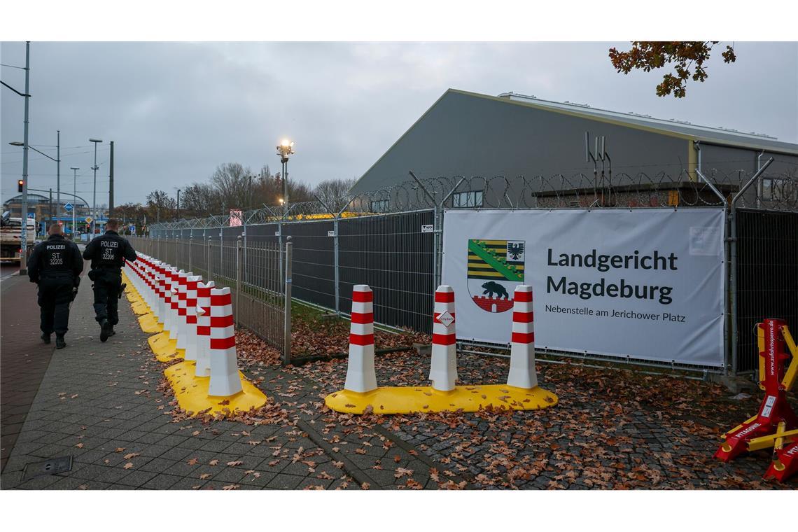 Polizisten laufen vor dem temporären Gerichtsgebäude des Landgerichtes Magdeburg Streife.