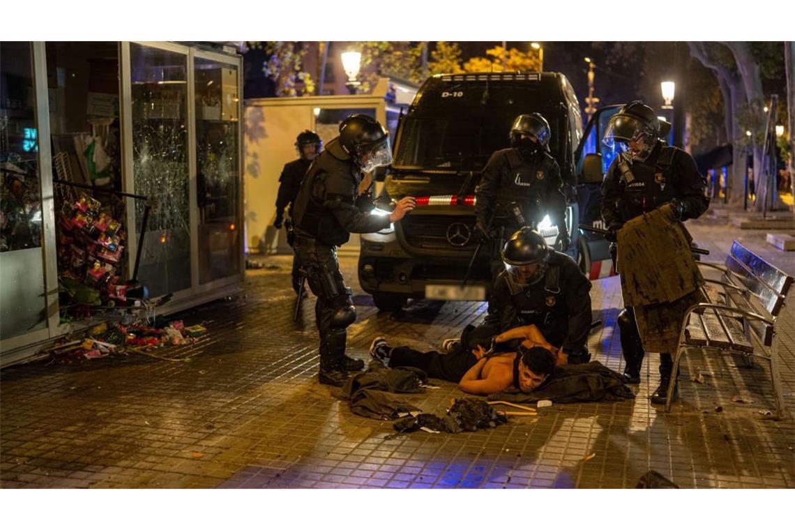 Polizisten nehmen eine Person im Rahmen von Ausschreitungen in Barcelona fest.
