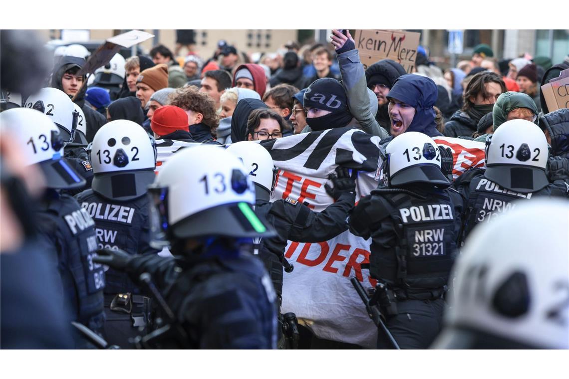 Bilder des Tages Polizisten schieben an der Uniklinik in Köln Demonstranten beiseite, um die Abfahrt von CDU-Chef Merz zu ermöglichen.
