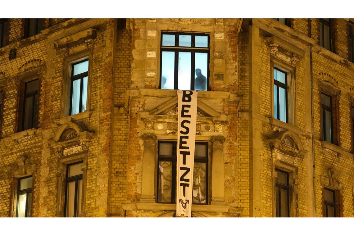 Polizisten sind in einem leerstehenden Haus im Leipziger Osten, an dessen Fassade ein Transparent mit der Aufschrift „Besetzt“ häng