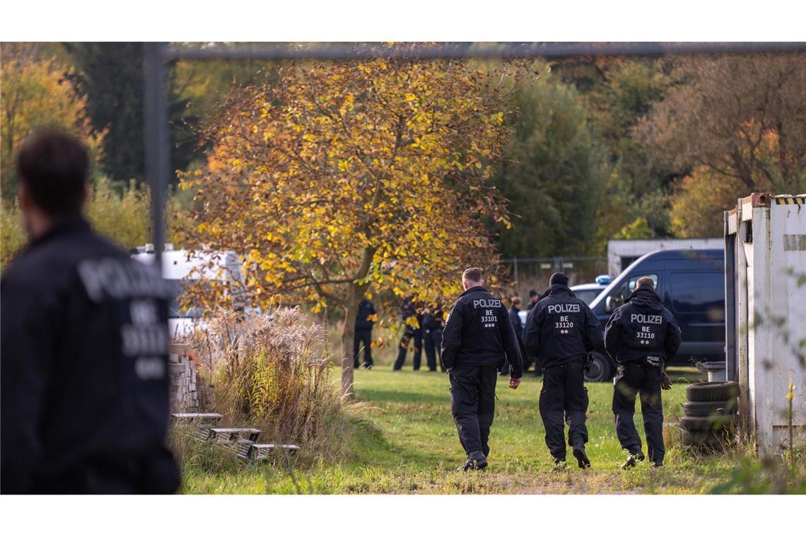 Polizisten stehen bei dem Großeinsatz auf einem Grundstück. (Archivbild)