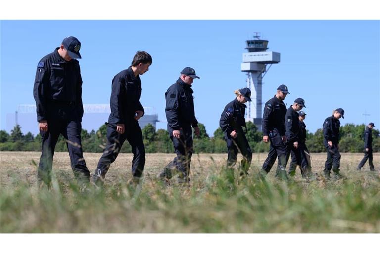 Polizisten suchen nach dem Drohnenvorfall am Flughafen Leipzig nach Drohnenspuren.