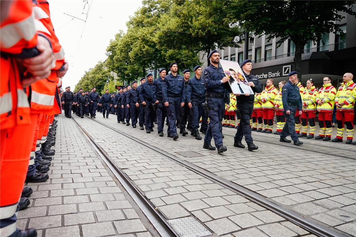 Polizist schildert Messerangriff - "Ich sah ihm die ganze Zeit in die Augen" Polizisten tragen ein Bild ihres Kollegen Laur bei der offiziellen Trauerfeier in Mannheim.