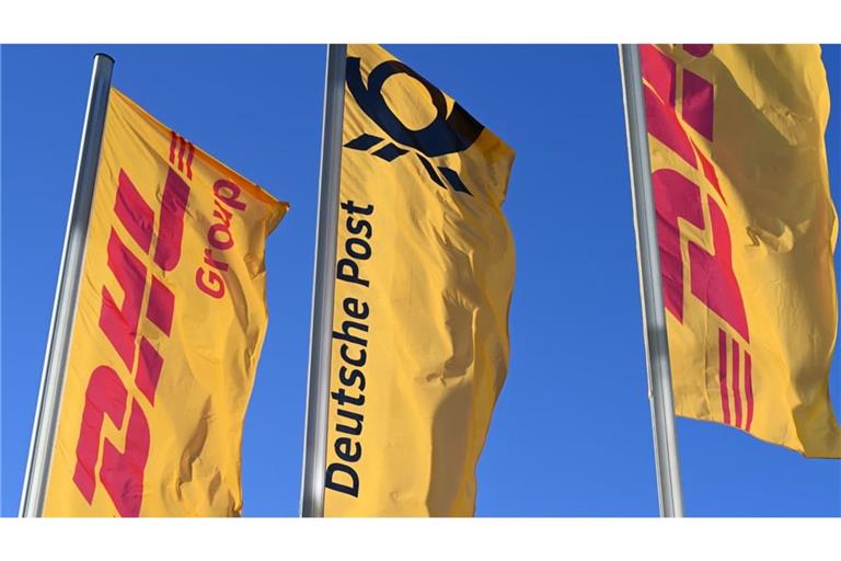 Post-Fahne mit Posthorn: ARCHIV - 13.01.2025, Nordrhein-Westfalen, Bonn: Fahnen des Logistikkonzerns DHL und seiner Brieftochter Deutsche Post (M) wehen vor der Konzernzentrale an Masten. Der Konzern hat sich von Deutsche Post AG zu DHL AG umbenannt. (zu dpa: «Bonner Logistikkonzern heißt jetzt DHL statt Deutsche Post») Foto: Wolf von Dewitz/dpa +++ dpa-Bildfunk +++
